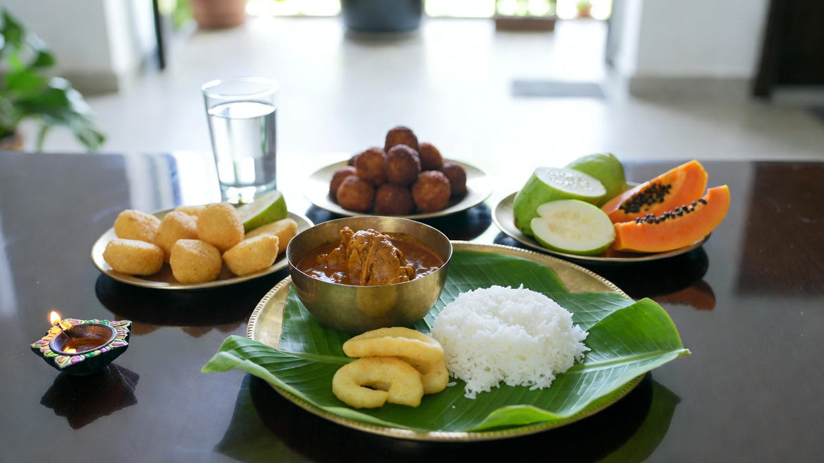 Bright Deepavali open house table with murukku, curry, rice and fresh fruit in daylight