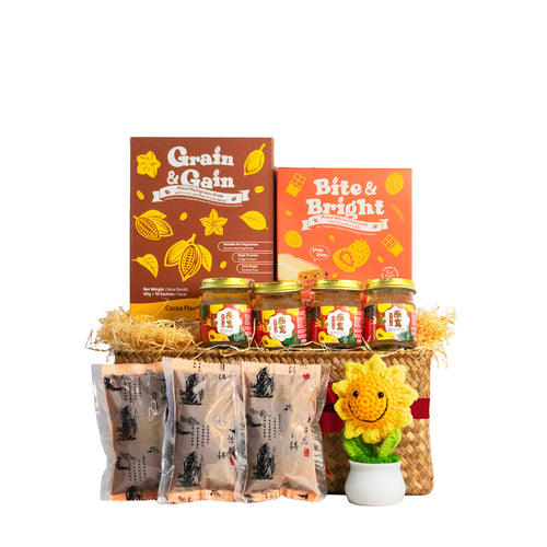 Flat lay of Pamper Snacktime Gift Basket contents: Bird's Nest, Bazhen, collagen bars, multi-grain drink, and crochet flower.